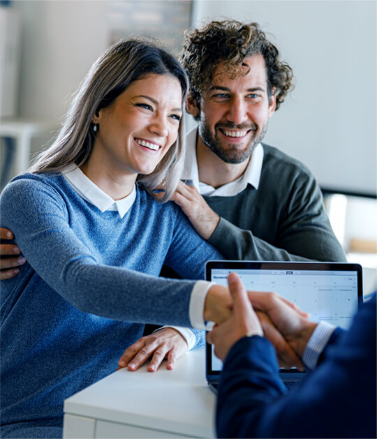 happy couple shaking hands with attorney